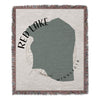 Woven blanket featuring the shape of Red Lake, Minnesota with fringed edges.