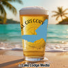 Glass of beer with "Lake Gregory" text and a blue state outline on a beach.
