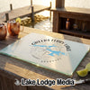 A glass cutting board printed with a Greers Ferry Lake, Arkansas map rests on a wooden dock.