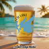 Glass of beer with a map of Birch Lake, MN on it, on a beach at sunset.