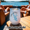 A white tumbler with a Lake Murray map graphic sits on a wooden table aboard a boat with two women.