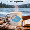 White mug with "Mono Lake California" map graphic, steams in front of rainy lake window.