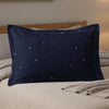 Navy blue pillowcase with scattered white snowflakes and dashed white trim.