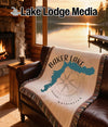 Baker Lake Washington map and compass blanket on leather couch with fireplace.