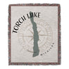 Torch Lake Michigan map on a woven blanket with compass design.