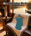 Woven blanket with Lake George, Florida map and compass design on leather couch.