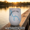 A white stemless wine tumbler featuring a map of Pickwick Lake, Alabama, rests on a wooden dock at sunset.