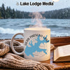 White mug with blue "Herb Parsons Lake Tennessee" design, steam rising, by a window.