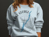 Light blue sweatshirt with Lake George New York map graphic and compass rose.