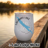 A white insulated wine tumbler featuring a blue map graphic and Lacamas Lake Washington text resting on a wooden dock.