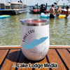 A white insulated wine tumbler featuring a Lake Erie graphic rests on a wooden dock with boats and people swimming in the background.