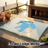 A glass cutting board featuring a blue map graphic of Lake Huron rests on a wooden table outdoors.
