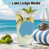 Glass of lemonade with lime and mint on beach with sailboat and sunglasses.