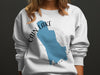 White sweatshirt with blue map of Lake Cain, Washington graphic and compass rose.