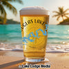 Glass of beer with "Douglas Lake" and lake graphic on beach background