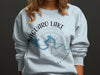 Light blue sweatshirt with "Saguaro Lake Arizona" text and compass logo.