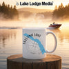 White mug with Eklutna Lake, Alaska map and compass design on a lake at sunrise.