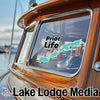Prior Life text sticker and teal lake outline on a wooden boat window by Lake Lodge Media.