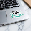 Amistad Life sticker with lake outline and copyright notice on laptop.