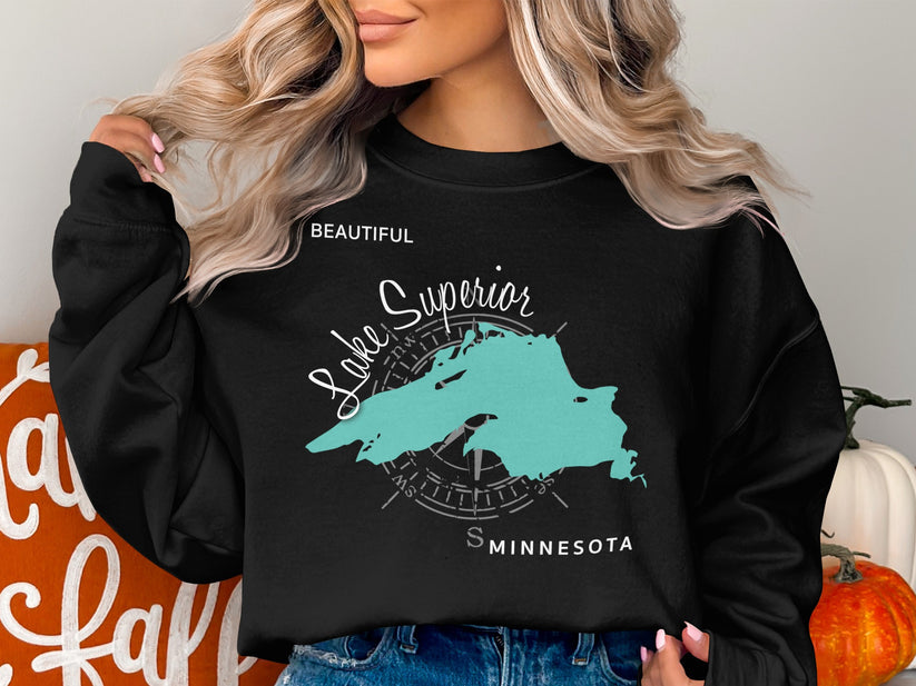 Black sweatshirt with teal Lake Superior map and compass graphic.