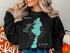 Black sweatshirt with "Beautiful Barlow Lake Michigan" map graphic.