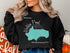 Black sweatshirt with a turquoise map of Walden Pond, Massachusetts.