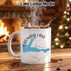 White mug with Grenada Lake map and compass design, steaming coffee.