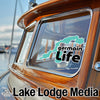 Teal lake-shaped sticker on boat window above "germain Life"; "Lake Lodge Media" text below.
