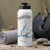 White water bottle with Shasta lake map and compass design, next to rolled towel and bag.