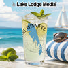 Glass with Lake Winnipeg map, compass, and mint on a beach with sailboat.