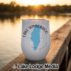 White travel tumbler featuring a blue map of Lake Winnebago, Missouri, resting on a wooden dock at sunset.