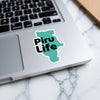 Turquoise sticker with black text "Piru Life" on a laptop keyboard.