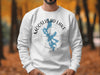 White sweatshirt with a Moosehead Lake Maine design featuring a compass and lake silhouette.