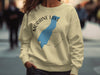 Light yellow sweatshirt with Moraine Lake Alberta graphic and compass rose.