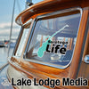 Saratoga Life sticker on a wooden boat window, with Lake Lodge Media logo.