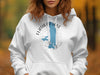 White hoodie with Flathead Lake, Montana silhouette and compass rose design.
