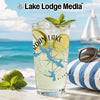Glass with Jordan Lake design, limes, and mint on a beach with a sailboat.