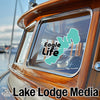 Teal "Eagle Life" sticker on a wooden boat window, with "Lake Lodge Media" text below.