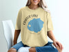 Crater Lake Oregon graphic on a tan t-shirt with compass rose detail.