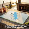 A glass cutting board featuring a blue map of Gull Lake, Michigan rests on a wooden dock.