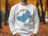 White sweatshirt with Lake Mascuppic, New Hampshire map and compass graphic.