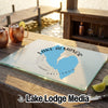 A rectangular glass cutting board with a blue Lake Almanor map design rests on a wooden outdoor bar.