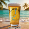 Beer glass with "Lake Okanagan" text and compass graphic on a beach.