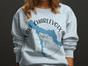 Light blue sweatshirt with Lake Charlevoix Michigan map and compass design.