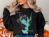 Black sweatshirt with teal compass and "Moss Lake North Carolina" map design.