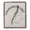 Woven throw featuring a Canandaigua Lake outline over a compass rose and text.