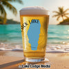 Glass of beer with "Black Lake" and Idaho outline on beach background.