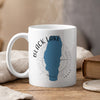 White mug with Black Lake Idaho map and compass design, emitting steam.
