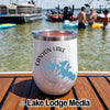 White insulated wine tumbler with a Canyon Lake Texas design sitting on a wooden boat deck.