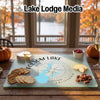 A glass cutting board featuring a map of Folsom Lake, California, surrounded by cheese, crackers, and fruit.